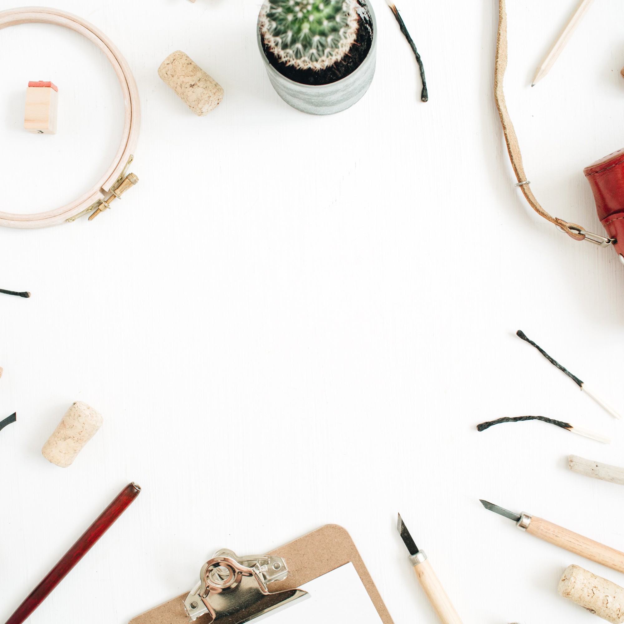 Workshop table with threads, hoops and a stitched linen sample